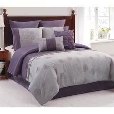 a bed with purple comforters and pillows