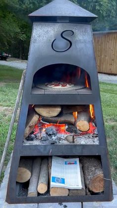 an outdoor wood burning oven with logs in it