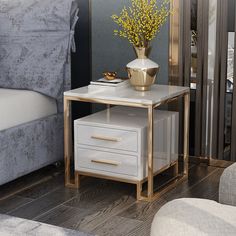 a white and gold end table next to a bed