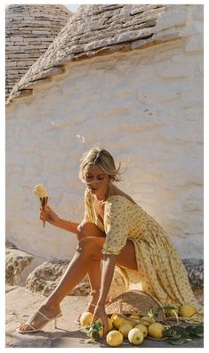 a woman sitting on the ground with lemons and an ice cream cone in her hand