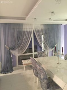 an elegant dining room with purple walls and curtains