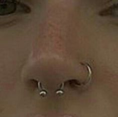 a woman with two piercings on her nose