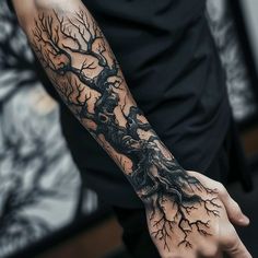 a man's arm with a tree and branches tattoo on his left arm, which is covered in black ink