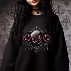 Cozy sweatshirt with a floral graphic, inspired by the vintage charm of a gothic Victorian cameo. Comfy classic fit and crew neckline for a comfortable and casual look. Looks great with leggings, black jeans, leather pants, or pair it with a skirt or a dress.  Perfect for both lounging with a book and going out on a colder day.                                                           Great gift idea for rose lovers, alternative fashion fans, romantic Valentine's gifts, or anyone who appreciates soft gothic and dark aesthetics.   ● Fits true to size. ● For best fit - measure one of your sweatshirts at home and compare it with the product size chart (see photos).  ● Made from a soft and durable fabric blend of 50% cotton and 50% polyester. ● Tear-away label. ● Eco-friendly, ethically grown Emo Style Sweatshirt For Fall Alternative Fashion, Black Gothic Sweatshirt With Graphic Print, Gothic Long Sleeve Sweatshirt With Graphic Print, Gothic Halloween Graphic Sweatshirt, Alternative Style Crew Neck Sweatshirt For Alternative Fashion, Victorian Cameo, Dark Aesthetics, Floral Sweatshirt, Gothic Rose