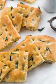 crackers with rosemary sprinkled on them sitting on a white surface