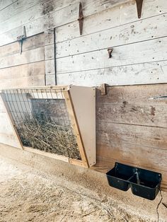 a barn with hay in bins on the side and some metal bars attached to the wall