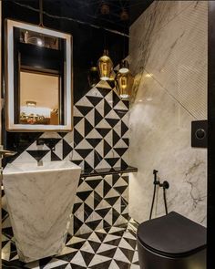 a black and white tiled bathroom with gold fixtures