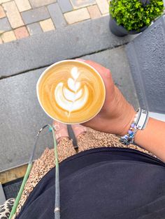 a person holding a cup of coffee in their hand