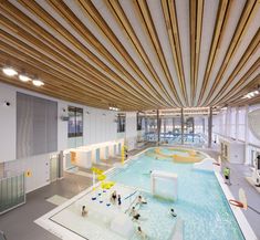 an indoor swimming pool with water slides and people in the area next to it,