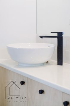 a white bowl sink sitting on top of a counter