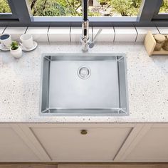 a stainless steel kitchen sink under a window