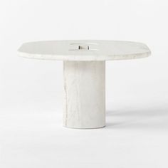 a white marble table with two holes in the middle and one hole at the top