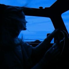 a woman driving a car in the dark