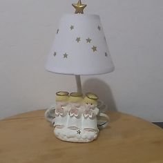 a lamp that is sitting on top of a table next to a cat figurine