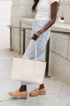 A timeless staple, the Charlotte Tote is sure to become your new on-the-go companion. This spacious shoulder bag is made from sleek, durable vegan leather and is built to fit everything you need for a busy day. Stow your laptop (up to 15"!), wallet, cosmetic bag, and more in this carryall tote. Details: 16" long x 12" height x 6" wide 10" strap drop Snap closure Smooth, silky vegan leather Stamped modern+chic logo Chic Logo, Carryall Tote, Busy Day, Timeless Accessories, Boutique Brands, Modern Chic, Laptop Case, Sneaker Heels, Plus Size Swimwear