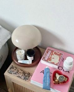 a table topped with books and candles next to a pillow on top of a bed