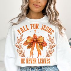 a woman wearing a white sweatshirt that says fall for jesus he never leaves