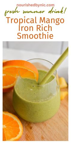 an orange and green smoothie in a glass with the title tropical mango iron rich smoothie