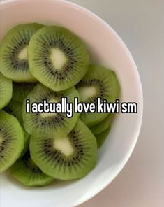 a white bowl filled with kiwi slices sitting on top of a table next to the words i actually love kiwi sm