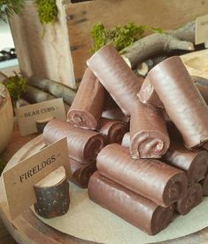 a pile of chocolate rolls sitting on top of a wooden table next to other items