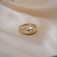 a diamond ring sitting on top of a white cloth