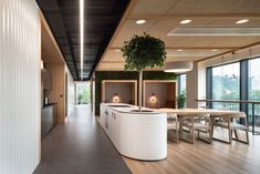 an office with wood flooring and white counter tops, along with large windows that look out onto the outdoors