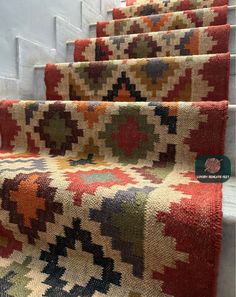 the carpeted stairs are lined with colorful rugs