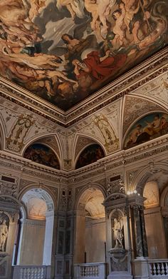 an ornate room with many paintings on the ceiling