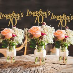 three mason jars filled with flowers sitting on top of a table next to each other