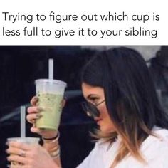 a woman holding up a drink in front of her face with the caption trying to figure out which cup is less full to give it to your sibling