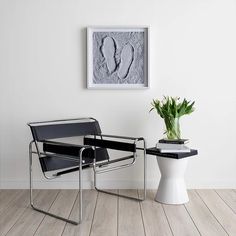 a chair with a plant in it next to a table that has a potted plant on it