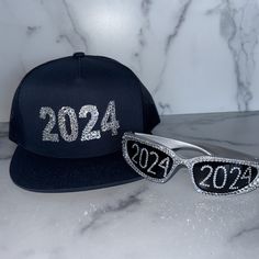 Silver Chrome 2024 Sunglasses with a 2024 Crystal Bling Trucker Hat. Party like it is 2024 and Celebrate NYE 2024 in Y2K style. Silver Chrome 2024 Sunglasses + Snapback Trucker Hat Statement style for NYE 2024, Graduation, New Years, Festivals, Concerts, Raves, Clubbing, Y2K vibes. Perfect for Graduation, New Years Parties, Festivals, Concerts, Raves, Clubbing, Rave Fam, Y2K Style | Unique Gift, Accessory Sunglasses and Adult fits all, adjustable snapback Trucker Hat with Silver Crystals, Hand Placed, Made to Order A unique and affordable gift and holiday, birthday, or anytime present. Glass details -  Frame Style: Wrap around, space Frame  Material: Plastic  Lenses: Mirrored Check out my festival Kandi, Beaded Friendship Bracelets - add to your order and save on shipping! https://www.etsy 2024 Sunglasses, Festival Kandi, Nye 2024, Bracelets Kandi, Hat Party, Friendship Bracelets With Beads, Space Frame, 2024 Graduation, Y2k Vibes