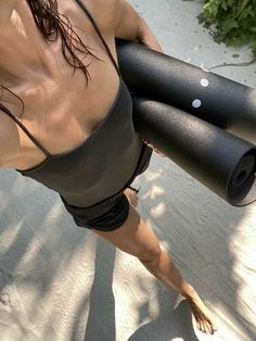 a woman is doing exercises with a yoga mat on her back while standing in the sun