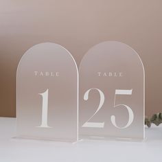 two clear acrylic table numbers are on display