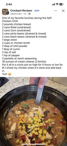 a person is cutting into a crock pot filled with chicken, corn and rice