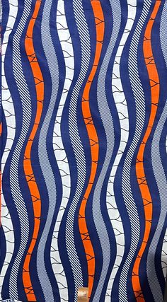 an orange and blue striped fabric with wavy lines on it's side, in front of a white background