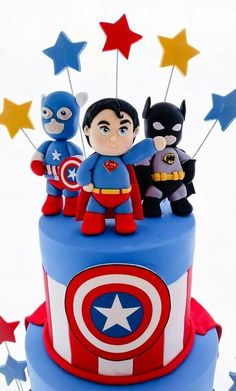 a birthday cake decorated with captain america and batman figurines on top of it