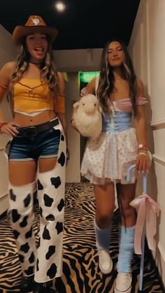 two girls dressed up as cowgirls walking down a hallway