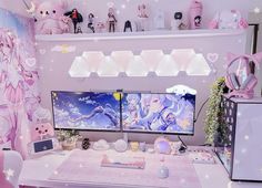 a desk with two computer monitors sitting on top of it next to a shelf filled with stuffed animals