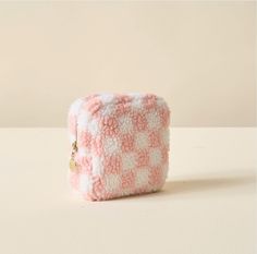 a small pink and white case sitting on top of a table next to a wall