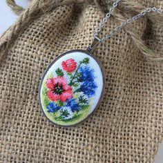 Embroidered necklace with dandelion, red poppy, and blue cornflower is a wonderful gift for women for any occasion. Flower jewelry pendant great gift for mother's birthday from daughter or son. Pendant with embroidery wildflower perfect for every day and for a special occasion. This pendant is made in the technique of micro-embroidery petit point on cotton canvas with cotton threads.  The size of each stitch is less than 1 mm. MATERIALS: The color of the base and chain-silver (not silver plated) Dainty Handmade Flower Necklace For Mom, Dainty Handmade Flower Necklace As Gift For Mom, Dainty Handmade Flower Necklace, Gift For Mom, Handmade Blue Necklaces As Gift For Mom, Handmade Flower Pendant Necklace For Mom, Handmade Flower Pendant Necklace As Gift For Mom, Embroidered Pendant Necklace For Gift, Bohemian Jewelry With Floral Embroidery For Gifts, Handmade Flower Pendant Necklace For Mother's Day