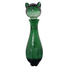 a green glass cat sitting on top of a table