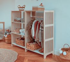 a closet with clothes and baskets on the floor next to a wall in a child's room