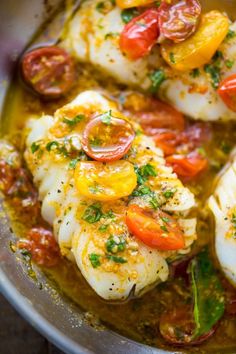 fish with tomatoes and herbs in a pan