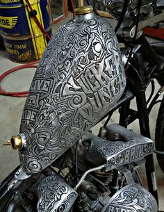 the motorcycle is decorated with intricate designs on it's seat and back fenders