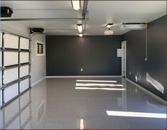 an empty room with two garage doors and no one in the area or on the floor