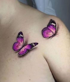 two purple butterflies on the back of a woman's shoulder, one with pink wings