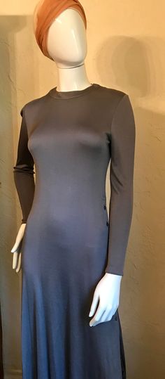 "This is a phenomenal vintage 1970's dress by Geoffrey Beene. It is s gray heavier silk jersey knit in a simple a sheath style but has those details to make it stand out. There are zippers at both shoulders and the long slinky skirt has buttons on one side from the waist to the hemto show as much or little leg as you like. Very boho chic....to go from day to dancing the night away at Studio 54. It is in good condition with just a tiny pull in one sleeve.. Measurements lying flat unstretched - Bu Fitted Crew Neck Evening Dress, Fitted Evening Dress With Crew Neck, Gray Fitted Dress With Crew Neck, Gray Fitted Crew Neck Dress, 1970s Long Sleeve Dresses For Daywear, Fitted Brown 1970s Dress, Geoffrey Beene Vintage, 1970s Long Sleeve Fitted Prairie Dress, Blue Halter Dress