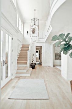 an open floor plan with white walls and wood floors, stairs leading to the second floor