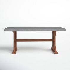 a gray table with wooden legs on a white background in front of a plain wall